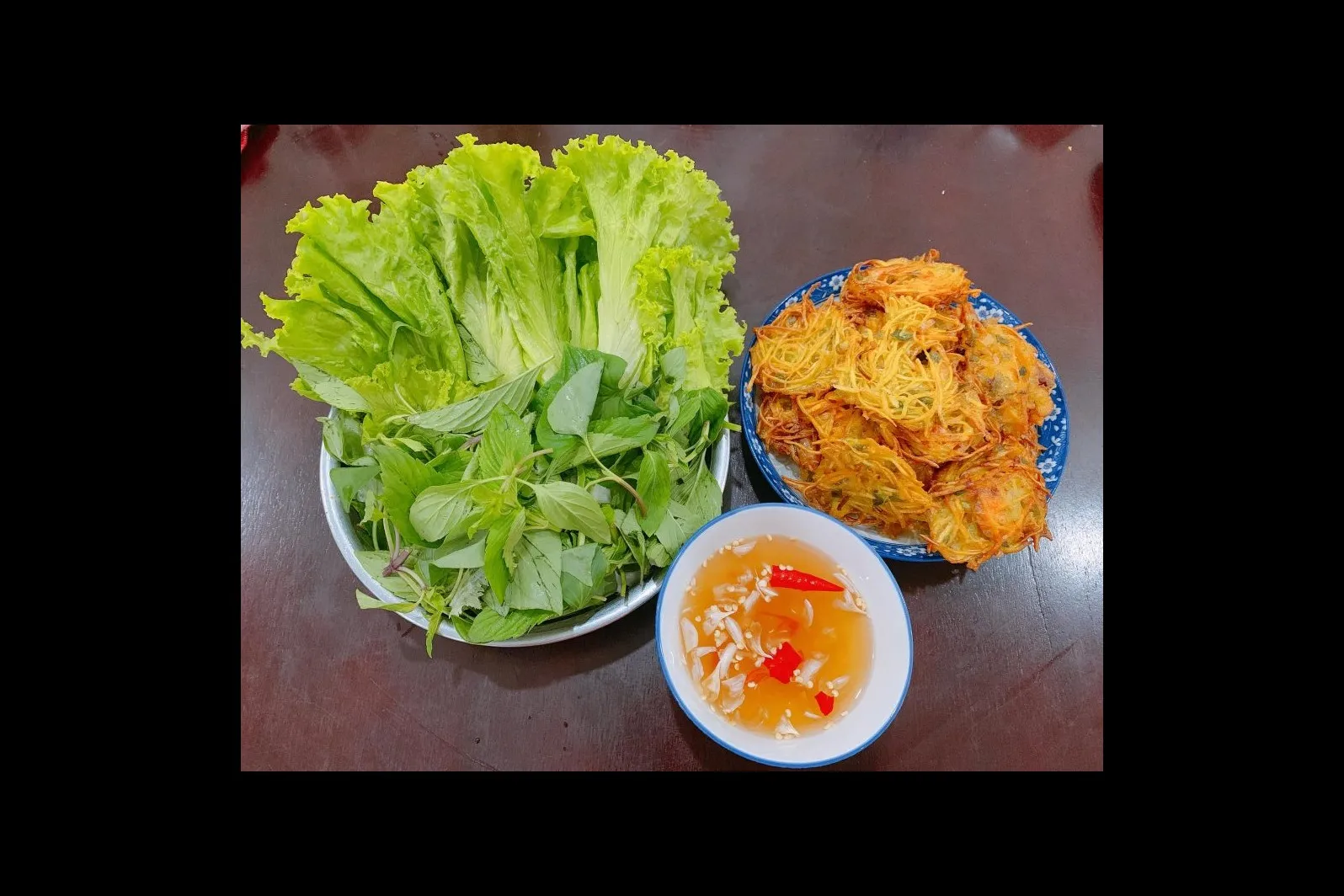 El puesto de pastel de camarones de 40 años que atrae clientes en un callejón de Đồng Xuân